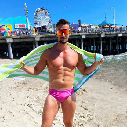 Man wearing pink swim briefs on a sunny beach