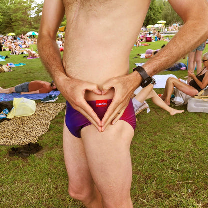 Front view of Rainbow Ombre swim briefs at the beach