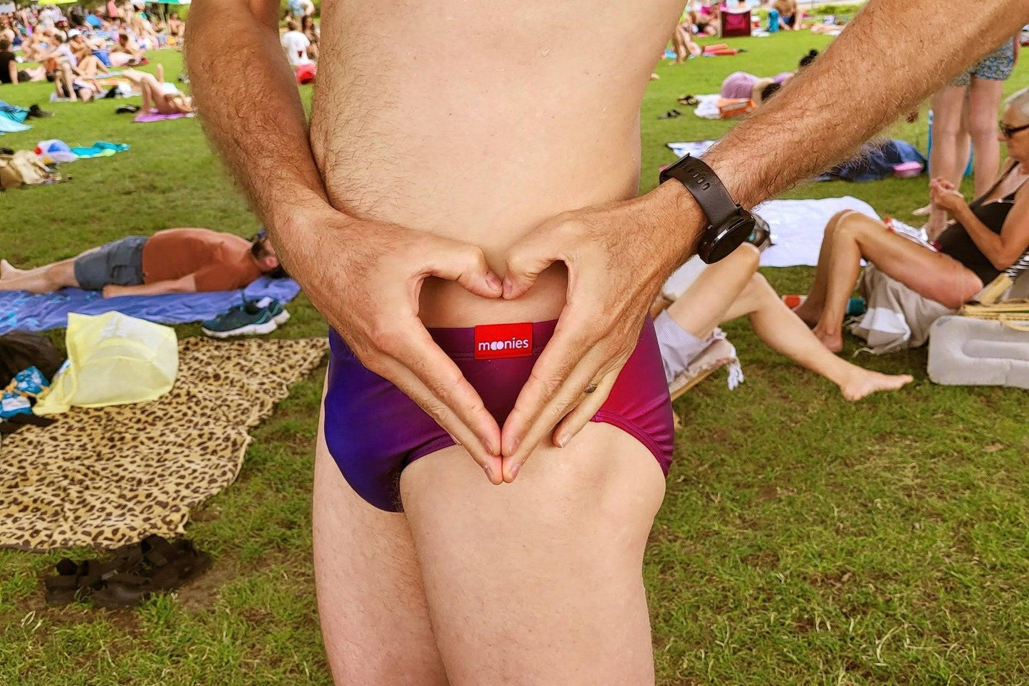 Model wearing rainbow ombre swim briefs on beach