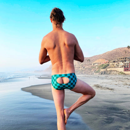 Back view of blue checkerboard swim briefs on beach