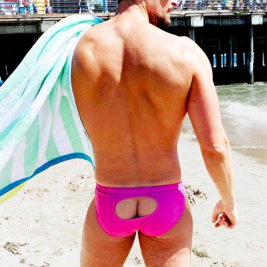 Back view of pink swim brief with open window at beach